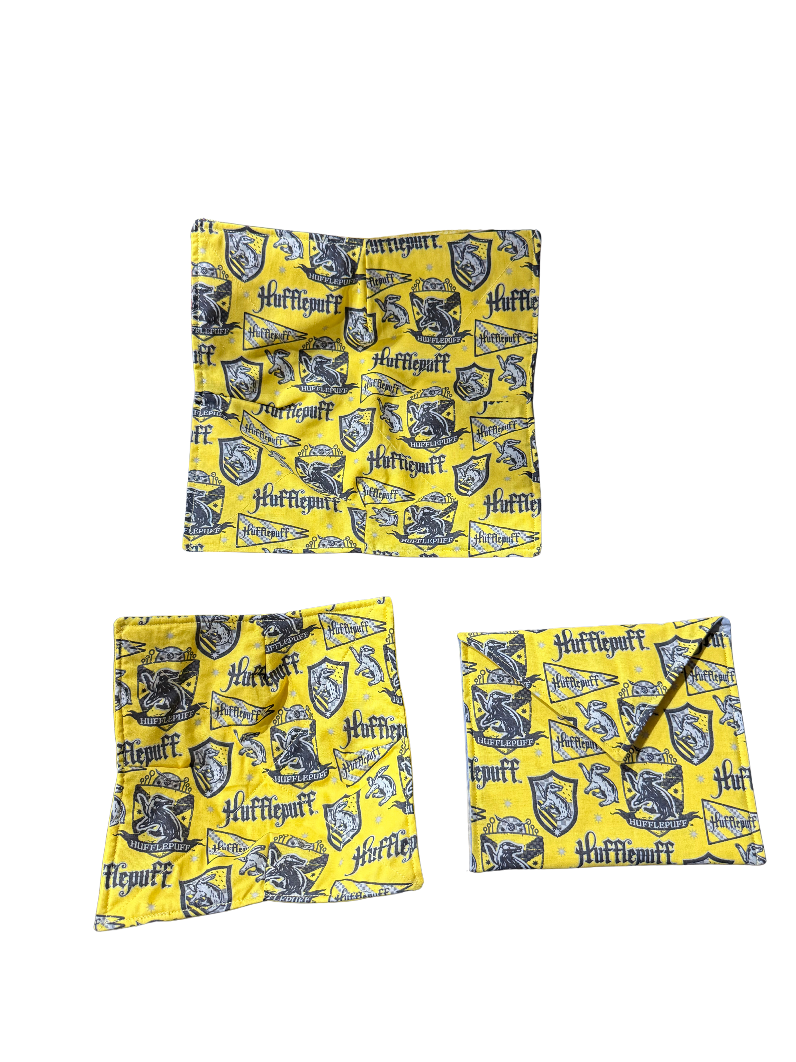 Set of three yellow fabric bags with 'Hufflepuff' pattern on a white background