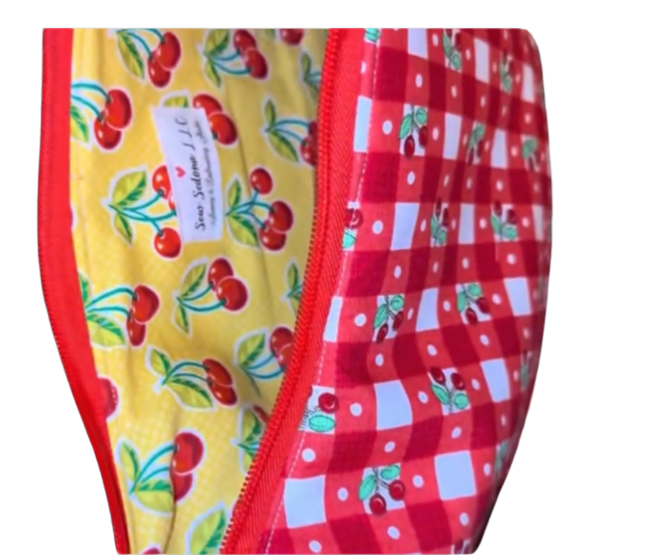 Two fabric swatches with different patterns, red checkered on the outside and yellow cherry on a white background